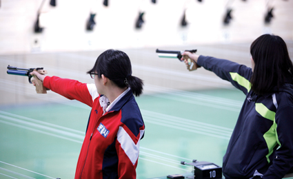 실내사격장에서 사격을 하고있는 사람들