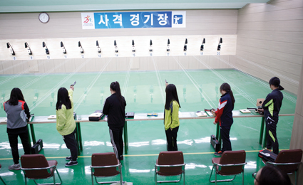 실내사격장에서 사격을 하고있는 사람들
